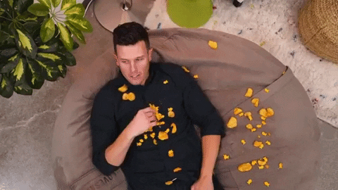 un homme allongé qui mange des Chips